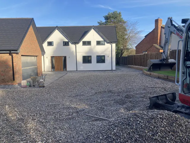Driveway groundwork in progress with a mini digger and stone sub-base