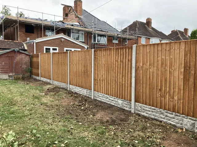 Tall close-board boundary fence on concrete posts