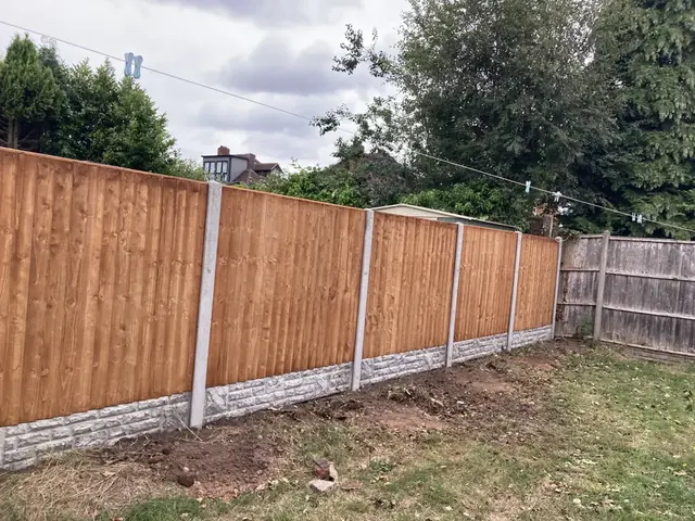 Close-board fence on concrete posts with concrete gravel boards