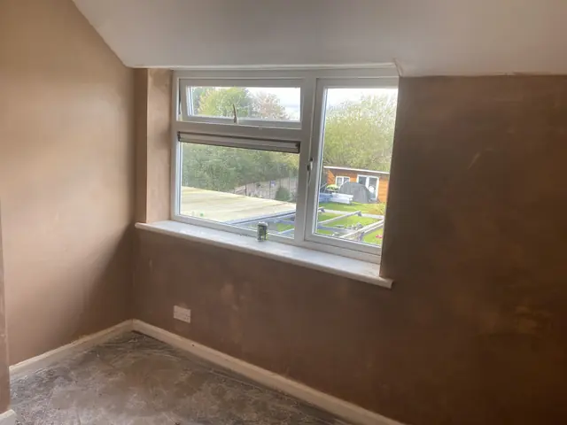 Freshly skimmed bedroom wall around a window, smooth and drying out