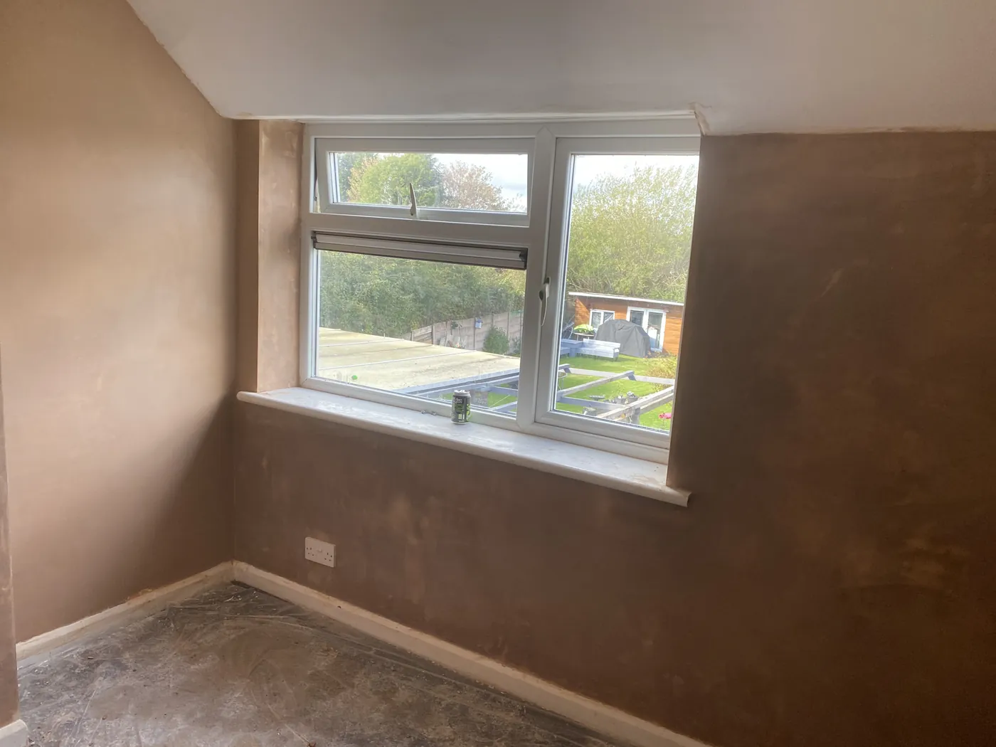 Freshly skimmed bedroom wall around a window, smooth and drying out
