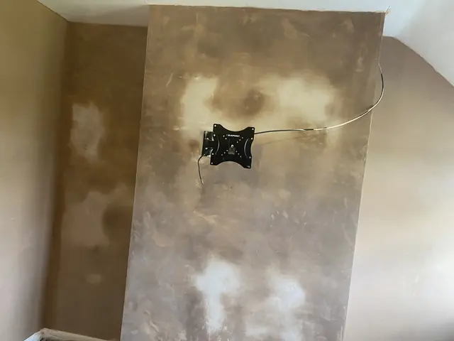 Fresh skim coat on a chimney breast, darker patches still drying