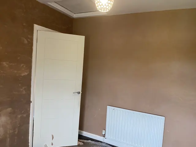 Newly skimmed bedroom walls beside a door and radiator