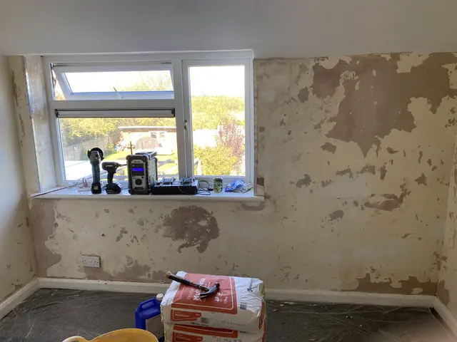 Bedroom window wall before plastering, with patched and flaking old finish
