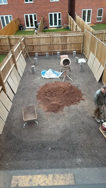 Garden dug out and levelled, with Craig compacting the stone sub-base and porcelain slabs stacked ready