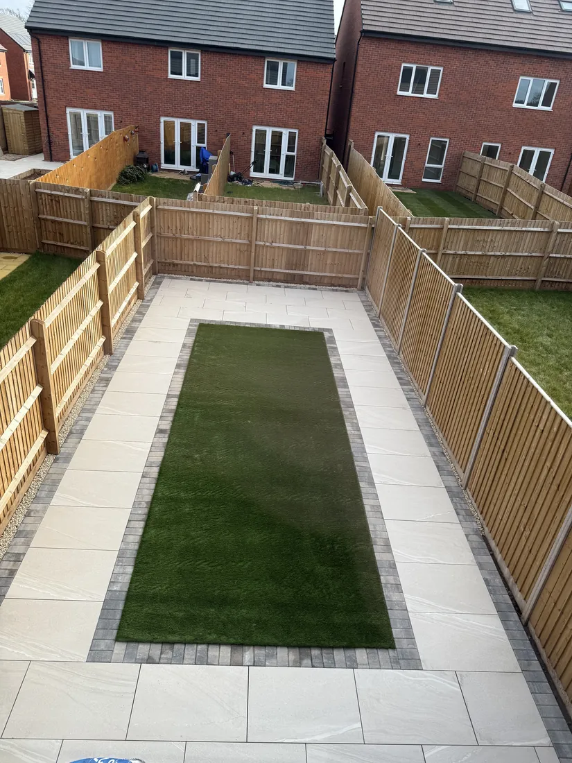 Finished garden from above: artificial grass framed by block paving and pale porcelain